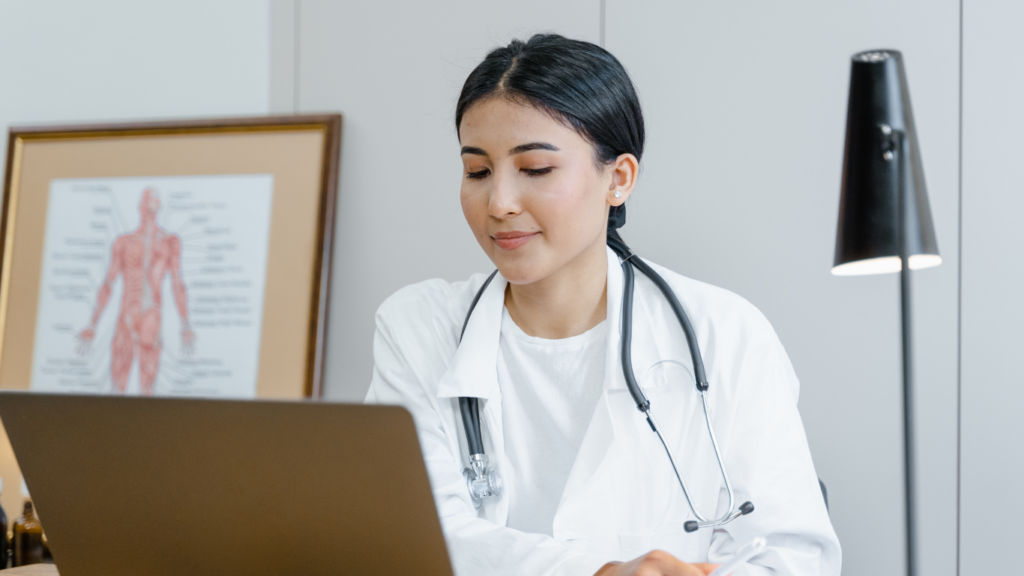 A doctor is sitting in front of a laptop