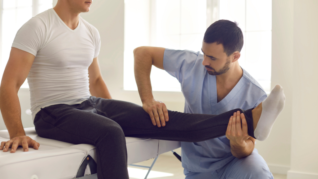 A physiotherapist helping a person to stretch their leg