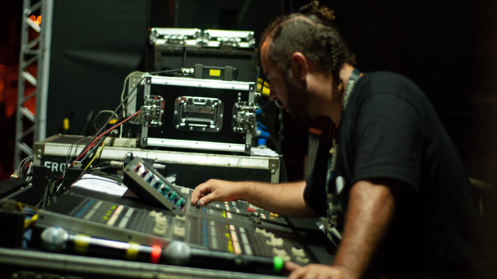 a person in a black shirt is working on a mixing board