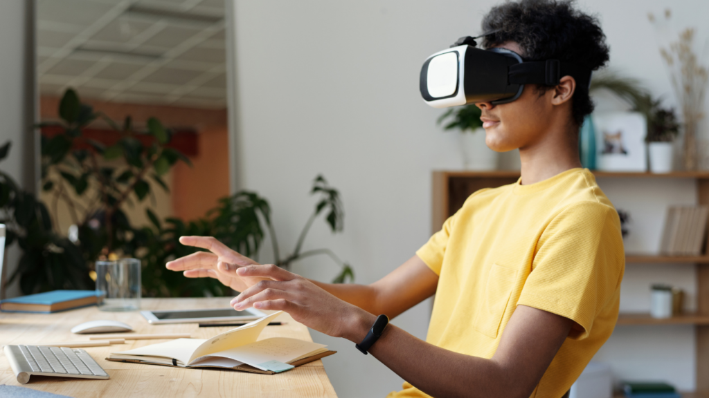 a person wearing virtual reality glasses at a desk