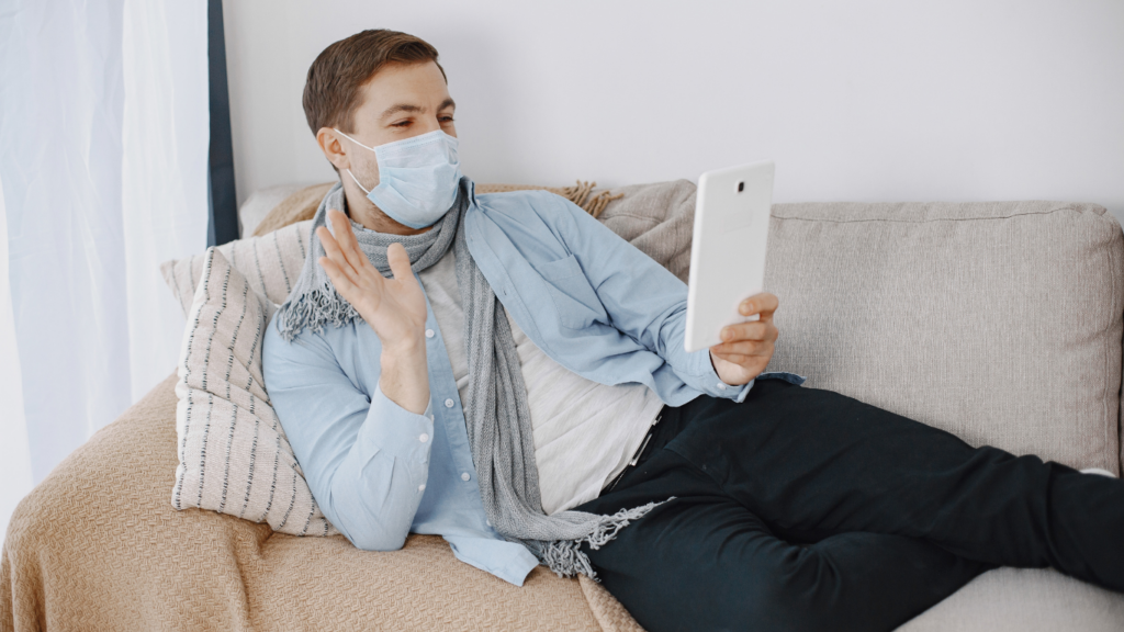 a person wearing a face mask is sitting on a couch