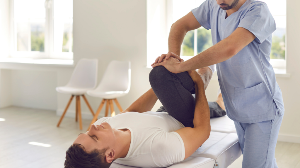 A physiotherapist helping a person to stretch their leg