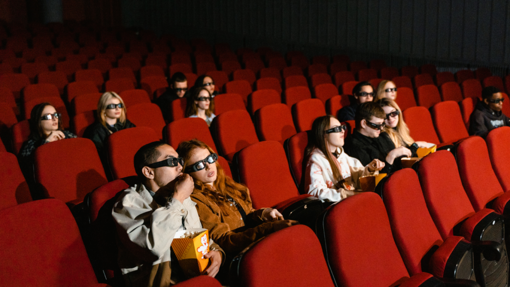 a movie theater with red seats and a fire truck on the screen