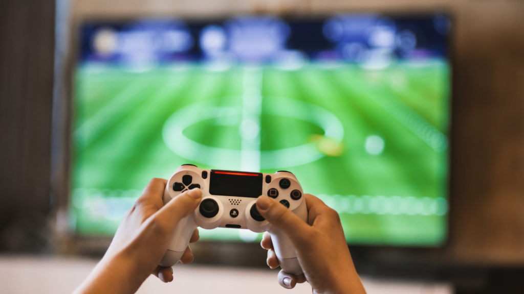 a person holding a video game controller in front of a colorful screen